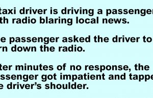 A taxi driver is driving a passenger.